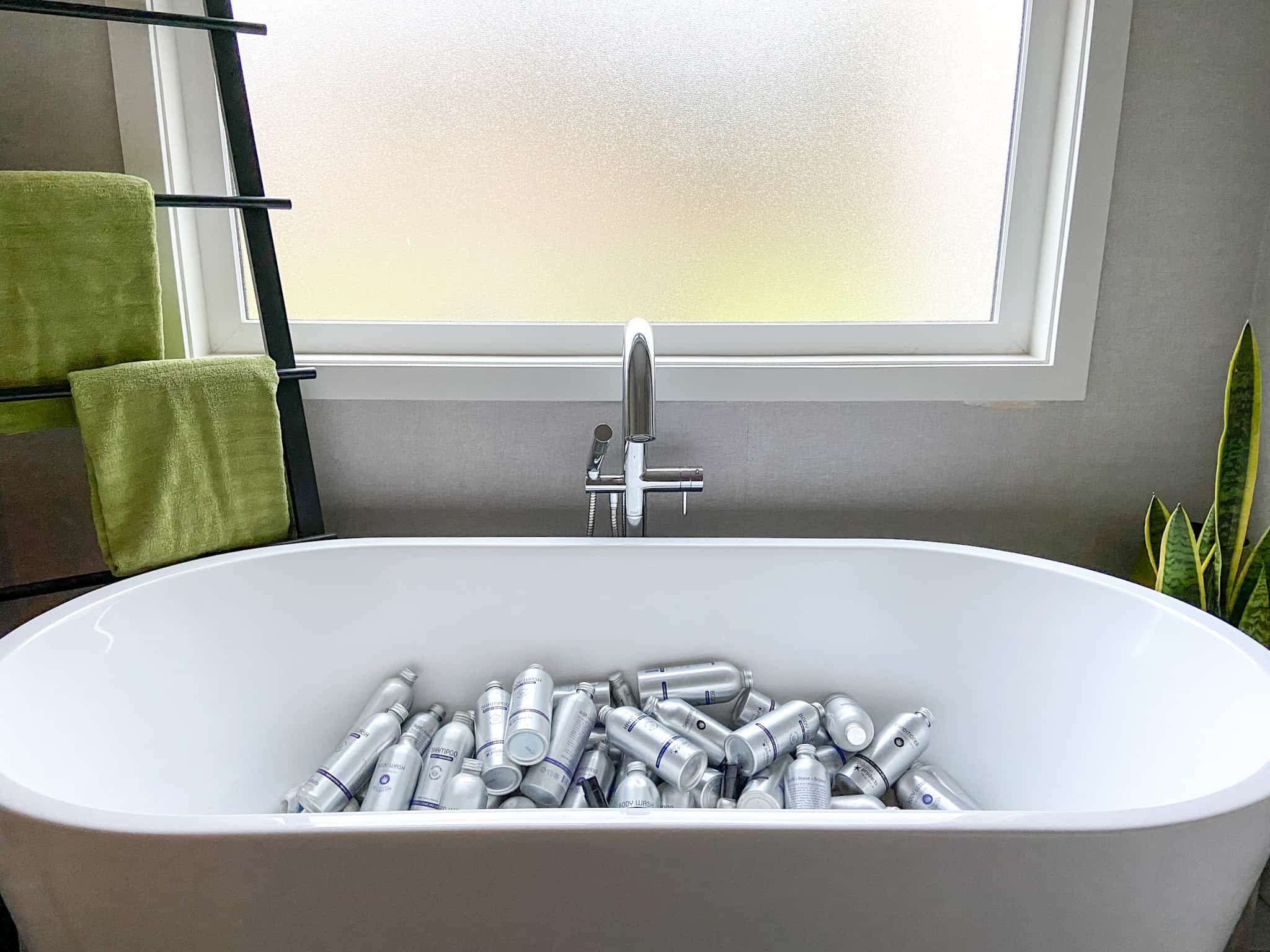Plaine Products bottles in a bathtub